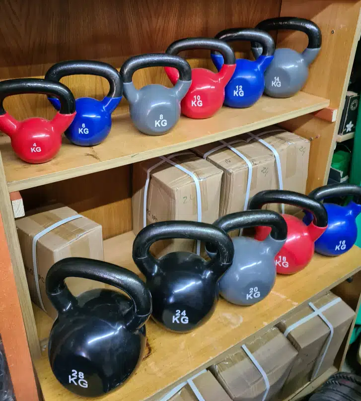 Prémium öntöttvas kettlebell (girja) súlyzók különböző méretekben, színes vinyl padlóvédő bevonattal és ergonomikus markolattal.